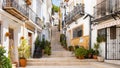 Narrow street with steps, white houses and potted plants in ancient neighborhood El Barrio or Casco Antiguo Santa Cruz Royalty Free Stock Photo