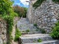 Narrow street with stone buildings, green plant and stairs in Dubrovnik, Croatia Royalty Free Stock Photo