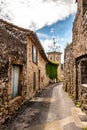 narrow street, stone houses and clock tower of an ancient village Royalty Free Stock Photo