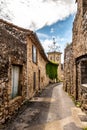 Narrow street, stone houses and clock tower of an ancient village Royalty Free Stock Photo
