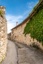 Narrow street, stone houses and ivy in an ancient village Royalty Free Stock Photo