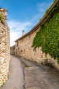 Narrow street, stone houses and ivy in an ancient village Royalty Free Stock Photo