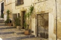 Narrow street with traditional houses with peeling plaster and flower pots along the walls of the old town of Finestrat Spain