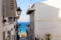 Narrow street of white houses with forged lanterns overlooking the sea in the old town of Altea, Spain on a hot sunny