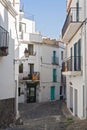 Narrow street with white houses in historical center of Cadaques Spain