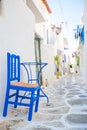 The narrow streets with blue balconies, stairs, white houses and flowers in beautiful village in Greece. Royalty Free Stock Photo