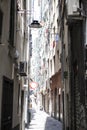 The narrow streets of the city of Genoa Italy. Old cobblestone road in the window grilles. Beautiful Perspective Lane. A good Royalty Free Stock Photo