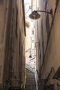 The narrow streets of the city of Genoa Italy. Old cobblestone road in the window grilles. Beautiful Perspective Lane. A good Royalty Free Stock Photo