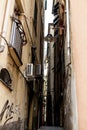 The narrow streets of the city of Genoa Italy. Old cobblestone road in the window grilles. Beautiful Perspective Lane. A good Royalty Free Stock Photo