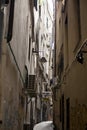 The narrow streets of the city of Genoa Italy. Old cobblestone road in the window grilles. Beautiful Perspective Lane. A good Royalty Free Stock Photo