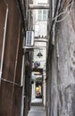 The narrow streets of the city of Genoa Italy. Old cobblestone road in the window grilles. Beautiful Perspective Lane. A good Royalty Free Stock Photo