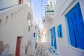 The narrow streets of greek island with blue balconies, stairs and flowers. Beautiful architecture building exterior Royalty Free Stock Photo