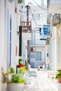 The narrow streets of greek island with blue balconies, stairs and flowers. Beautiful architecture building exterior Royalty Free Stock Photo