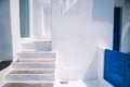 The narrow streets of the island with blue balconies, stairs and flowers in Greece. Royalty Free Stock Photo