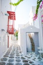 The narrow streets of the island with blue balconies, stairs and flowers in Greece. Royalty Free Stock Photo