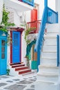 The narrow streets of the island with blue balconies, stairs and flowers. Mykonos, Greece. Royalty Free Stock Photo