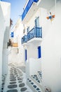 The narrow streets of the island with blue balconies, stairs and flowers in Greece. Royalty Free Stock Photo