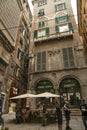 Narrow streets and plateau with street cafe at historic center of Genoa city