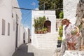 Narrow streets and typical Greek buildings in the city of Lindos on the island of Rhodes. Residential buildings at the foot of th