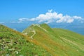 A narrow track road path at mountainside going up around a top o Royalty Free Stock Photo