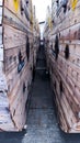 a narrow tunnel of wooden barrels with yellow and black labels. Royalty Free Stock Photo