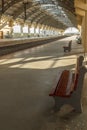 Narrow view of a locomotive electric train station platform with unoccupied seat and covered tunnel, Chennai, India, Mar 29 2017