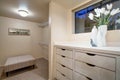 Narrow walk-in closet features built-in drawers