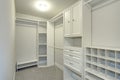 Narrow walk-in closet lined with built-in drawers