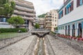 Narrow water stream flowing down through stone paved riverbed built to protect from flash flooding in Montreux town, Vaud,