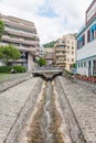 Narrow water stream flowing down through stone paved riverbed built to protect from flash flooding in Montreux town, Vaud,