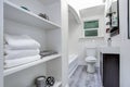 Narrow white bathroom interior with open shelves