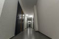 Narrow white corridor with many doors in an apartment building Royalty Free Stock Photo