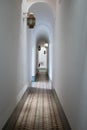 Narrow white corridor with squared pattern floor on an ancient house in Marrakesh, Morocco Royalty Free Stock Photo