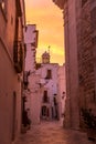 Narrow white street in Locorotondo oldtown during sunset, region Puglia, Italy
