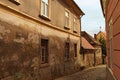 Narrow winding cobblestone road between ancient houses. Some parts of graffiti on the wall. Old part of the city Maribor, Slovenia Royalty Free Stock Photo