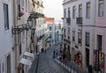 Narrow winding touristy center street of Lisbon, Portugal Royalty Free Stock Photo