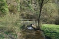 Narrow wooden bridge over a river in a park Royalty Free Stock Photo