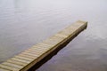 Wood pontoon on the lake seems to float in the sky with the reflection