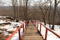 Narrow wooden stepped path leading from the hill down to the river on a sunny winter day