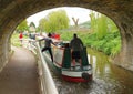 Narrowboat passing under canal bridge Royalty Free Stock Photo