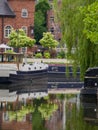 Narrowboat, trees and their reflections in the canal water in Castlefield, Manchester, UK Royalty Free Stock Photo