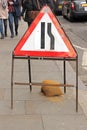 Narrowing street traffic sign on London sidewalk