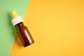 Nasal drops bottle composition, glass bottle on yellow and green background