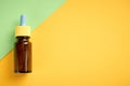 Nasal drops bottle composition, glass bottle on yellow and green background