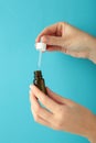 Nasal drops in hand on blue background. Runny nose treatment concept. Vertical photo Royalty Free Stock Photo