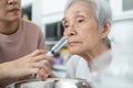 Nasal irrigation,female caregiver is helping senior woman wash her nose,nasal cleaning with syringe and saline,elderly people