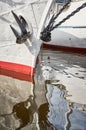 Nasal part of a sailing frigate of white color with an anchor on a nose, bright reflection in water