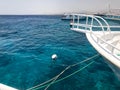 The nasal parts of white ships moored, standing in the open blue sea on the dock against the blue sea