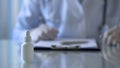 Nasal spray bottle on doctor table, therapist prescribing medication, background Royalty Free Stock Photo