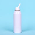 Nasal spray bottle, sea water for cleanse. Isolated on blue background
